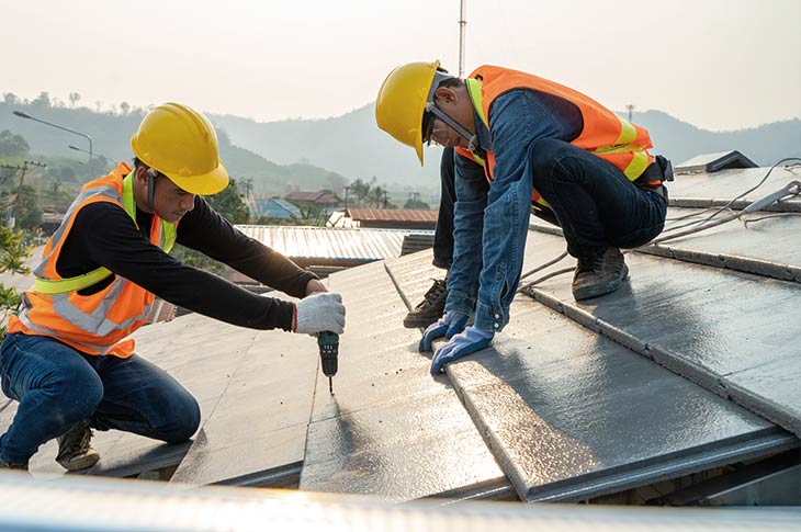 Workers installing fire-resistant roofing materials on a home to enhance Pacific Palisades home fireproofing.