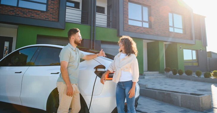 Homeowners charging an electric vehicle outside a modern home, illustrating EV charger installation cost in Pacific Palisades