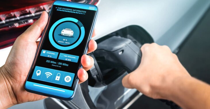 Driver checks EV charging status on a smartphone while connecting the charging cable.