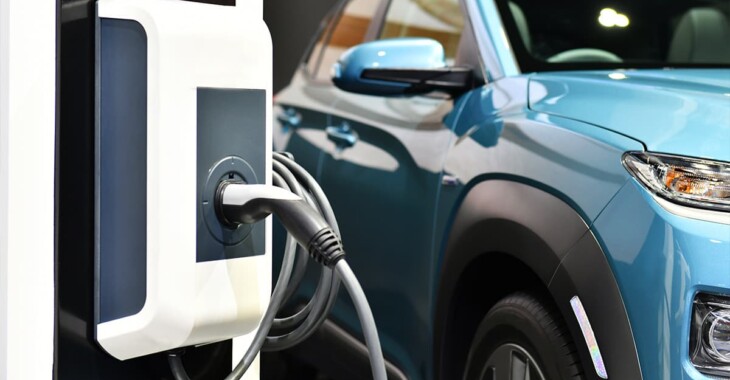 Wall-mounted EV charger beside a blue electric vehicle, illustrating home charging options in Los Angeles.